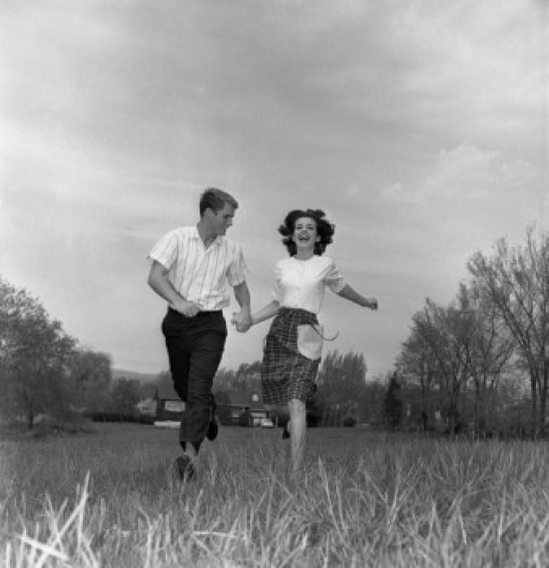 Young couple running through field Canvas Art - (18 x 24)