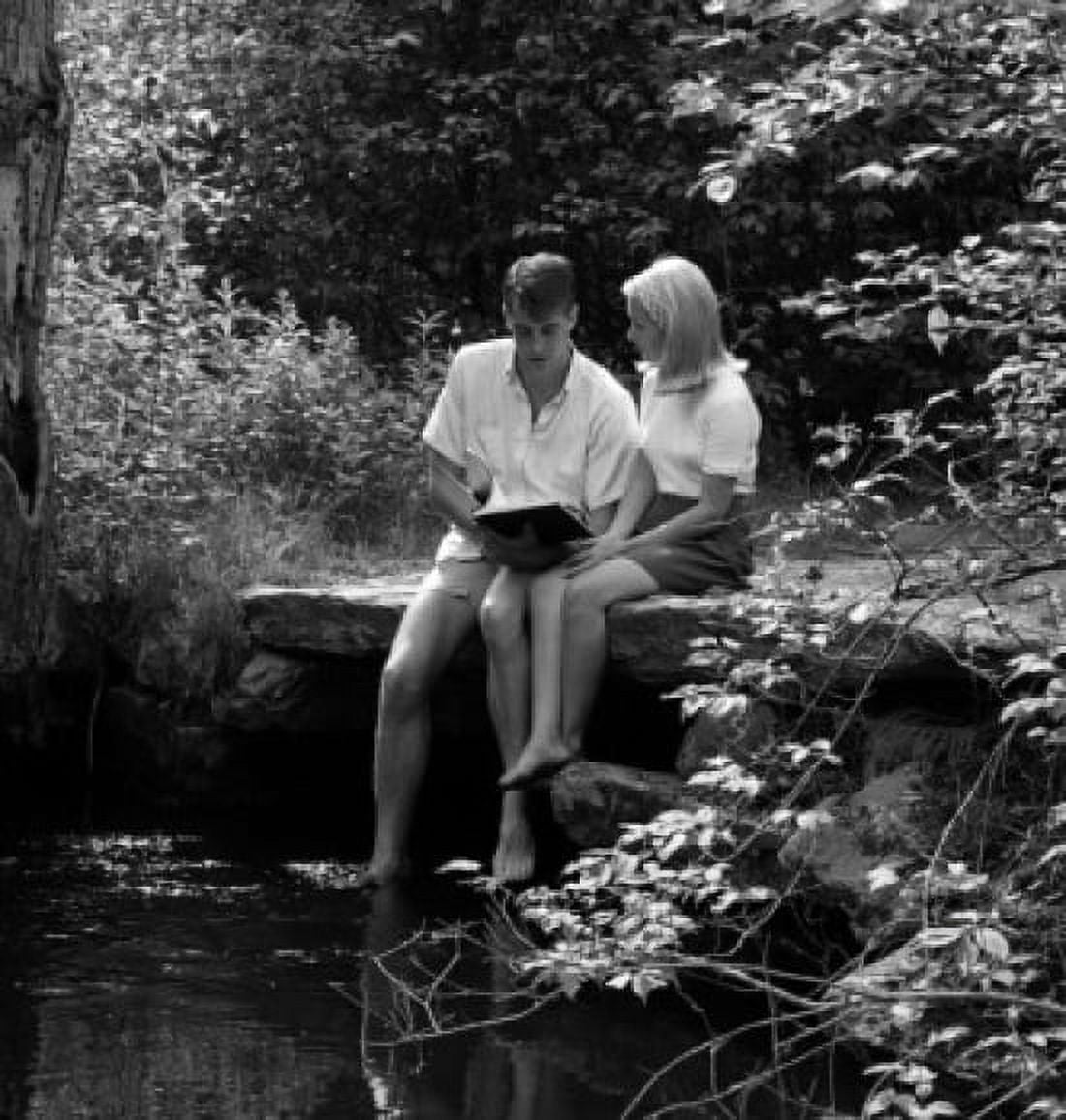 Young couple sitting by pond Canvas Art - (18 x 24)