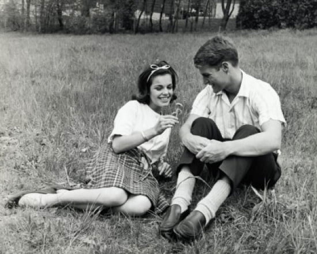 Young couple sitting in a park smiling Canvas Art - (18 x 24)