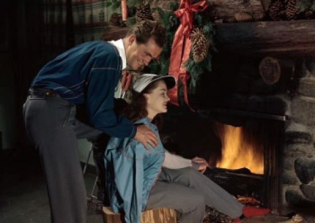Young couple sitting near a fireplace Canvas Art - (18 x 24)