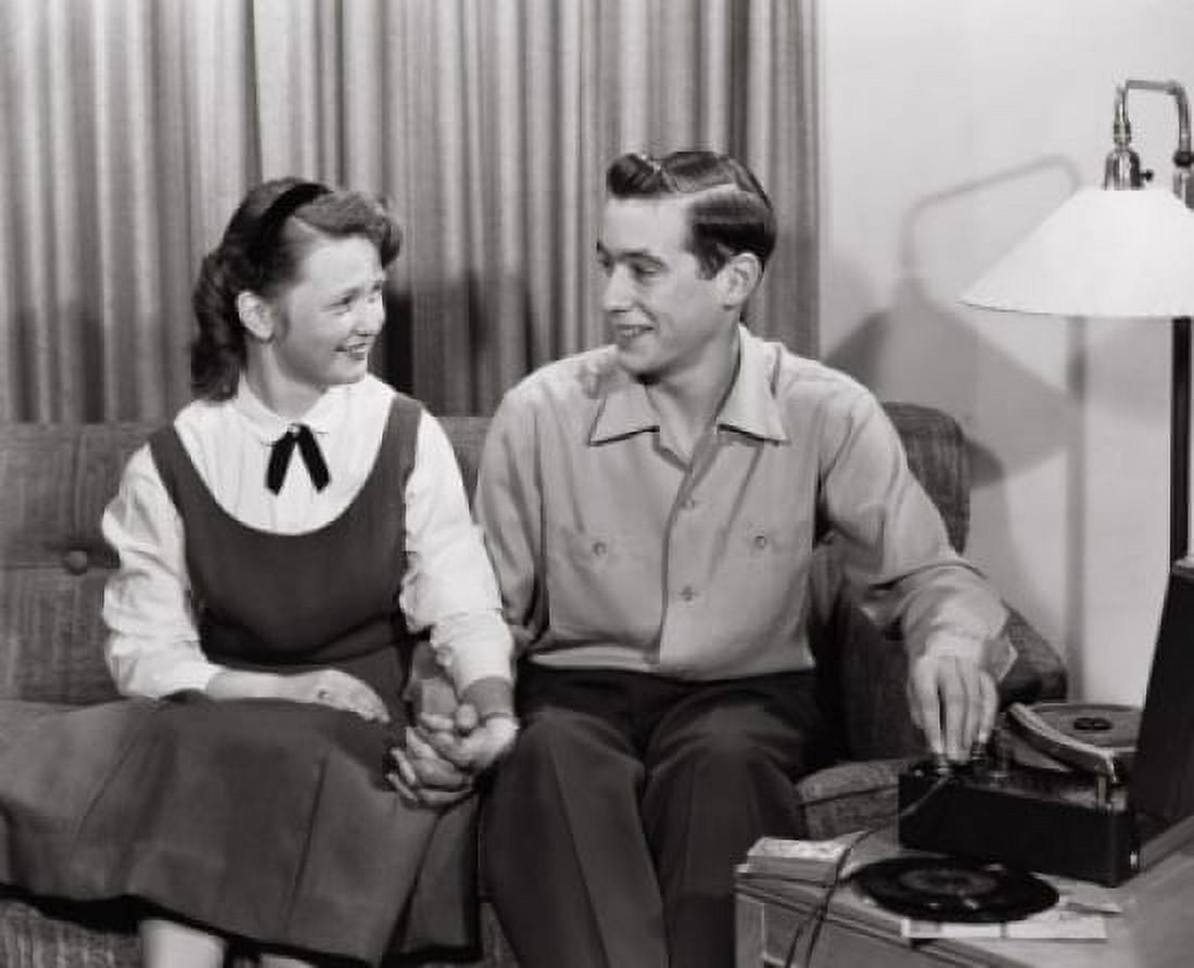 Young couple sitting on sofa near record player Canvas Art - (18 x 24)