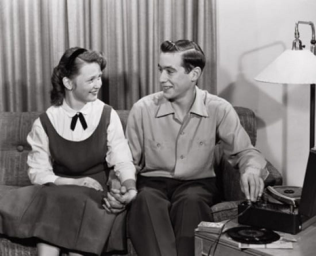 Young couple sitting on sofa near record player Canvas Art - (24 x 36)