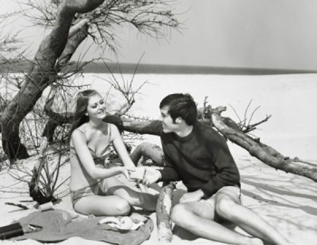 Young couple sitting on the beach Canvas Art - (18 x 24)