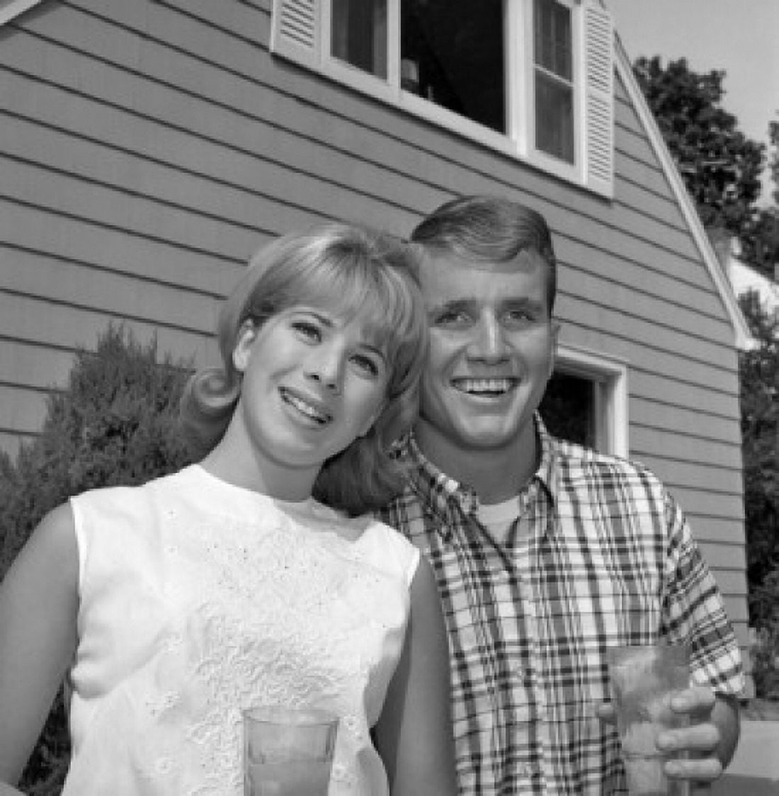 Young couple standing in front of house Canvas Art - (24 x 36)
