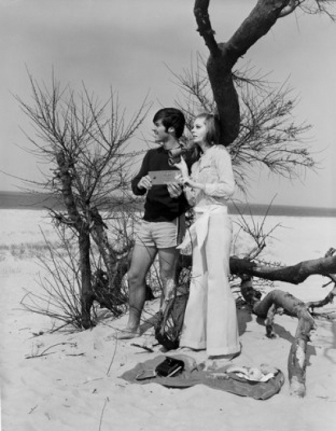 Young couple standing on sand dune under bare bush Canvas Art - (24 x 36)