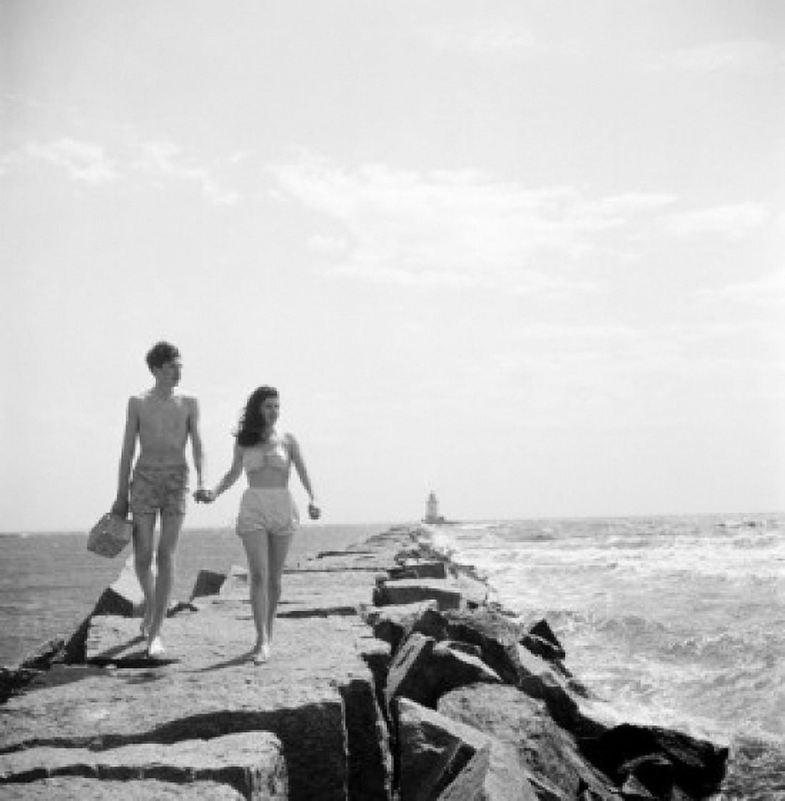 Young couple walking along groyne Canvas Art - (24 x 36)