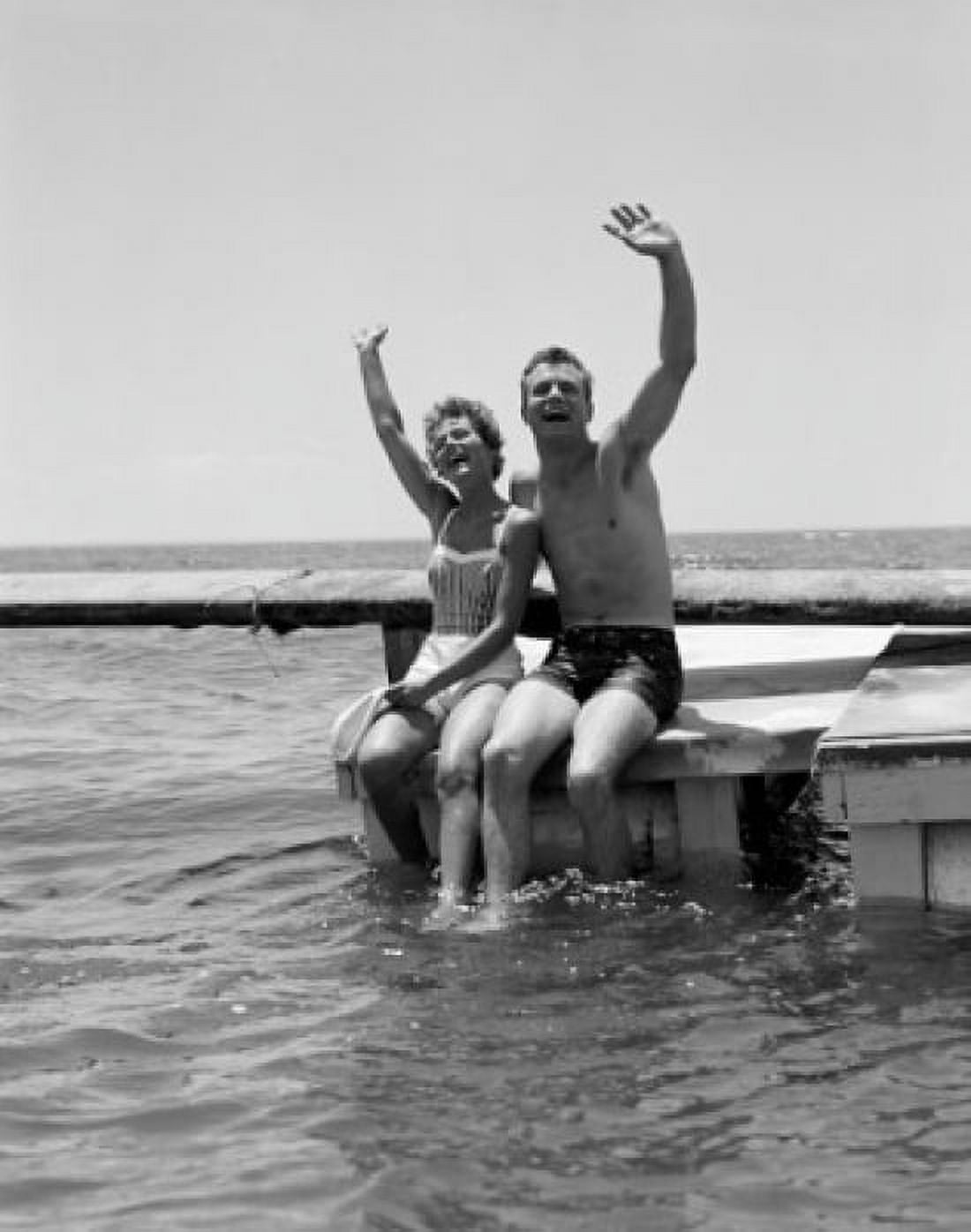 Young couple waving on pier at sea Canvas Art - (24 x 36)