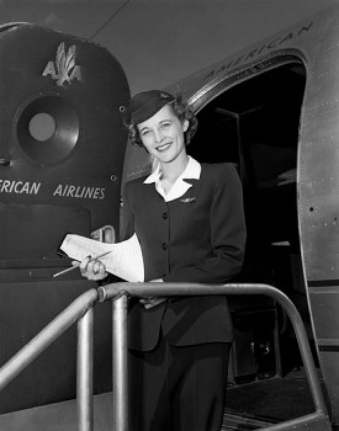 Young female flight attendant standing in aiplane door and smiling Canvas Art - (24 x 36)