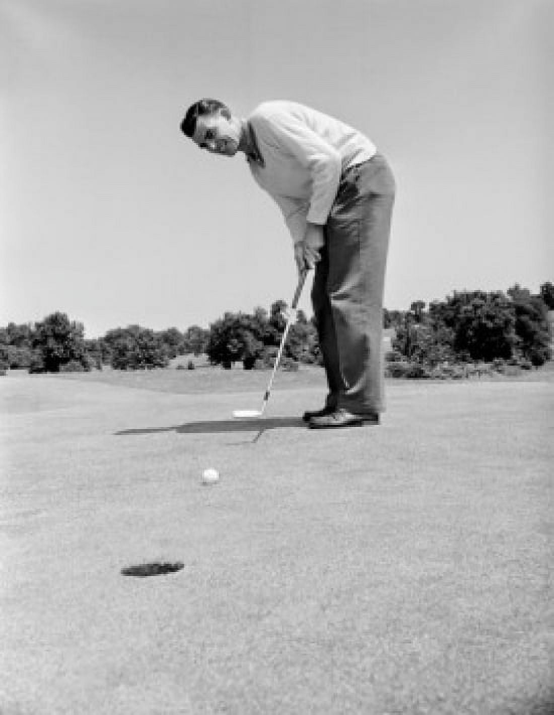 Young golfer putting golf ball into hole Canvas Art - (24 x 36)