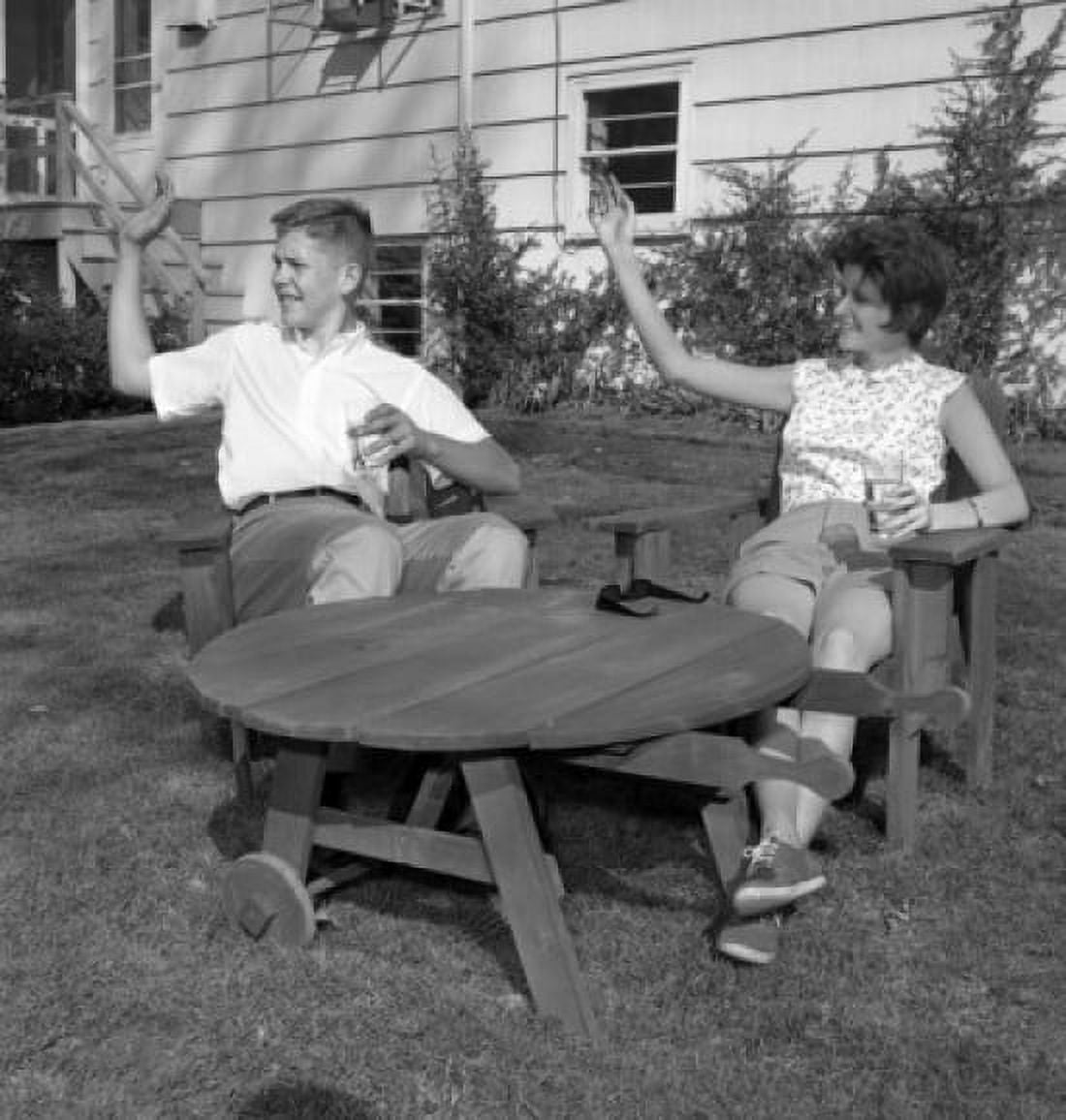 Young man and young woman sitting at outdoor table and waving Canvas Art - (18 x 24)