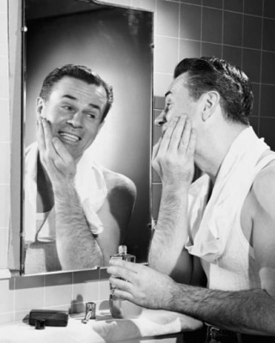 Young man applying aftershave to his face Canvas Art - (18 x 24)