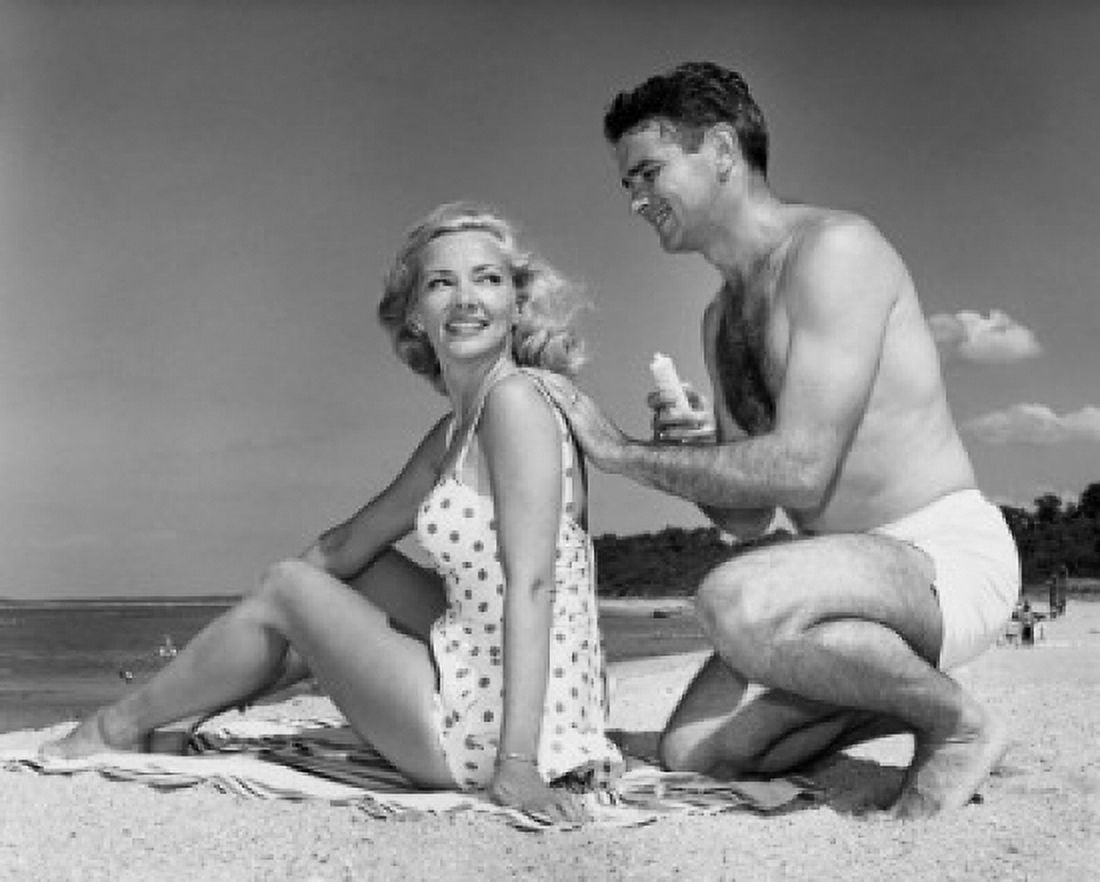 Young man applying suntan lotion on a young womans back at the beach Canvas Art - (18 x 24)