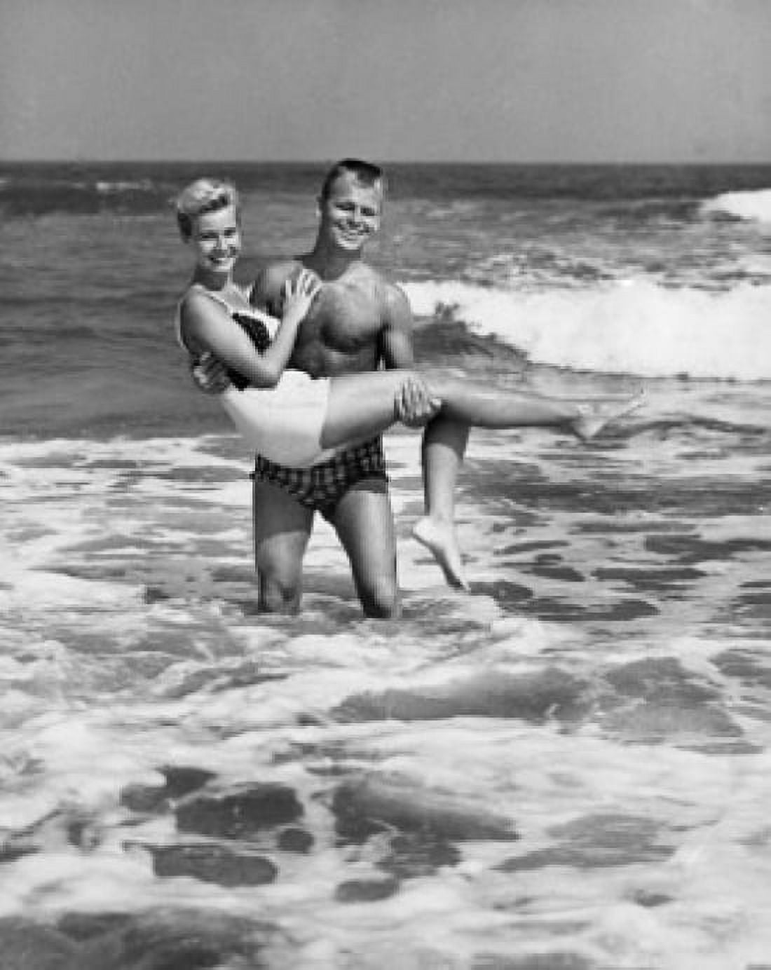 Young man carrying young woman in water Canvas Art - (24 x 36)