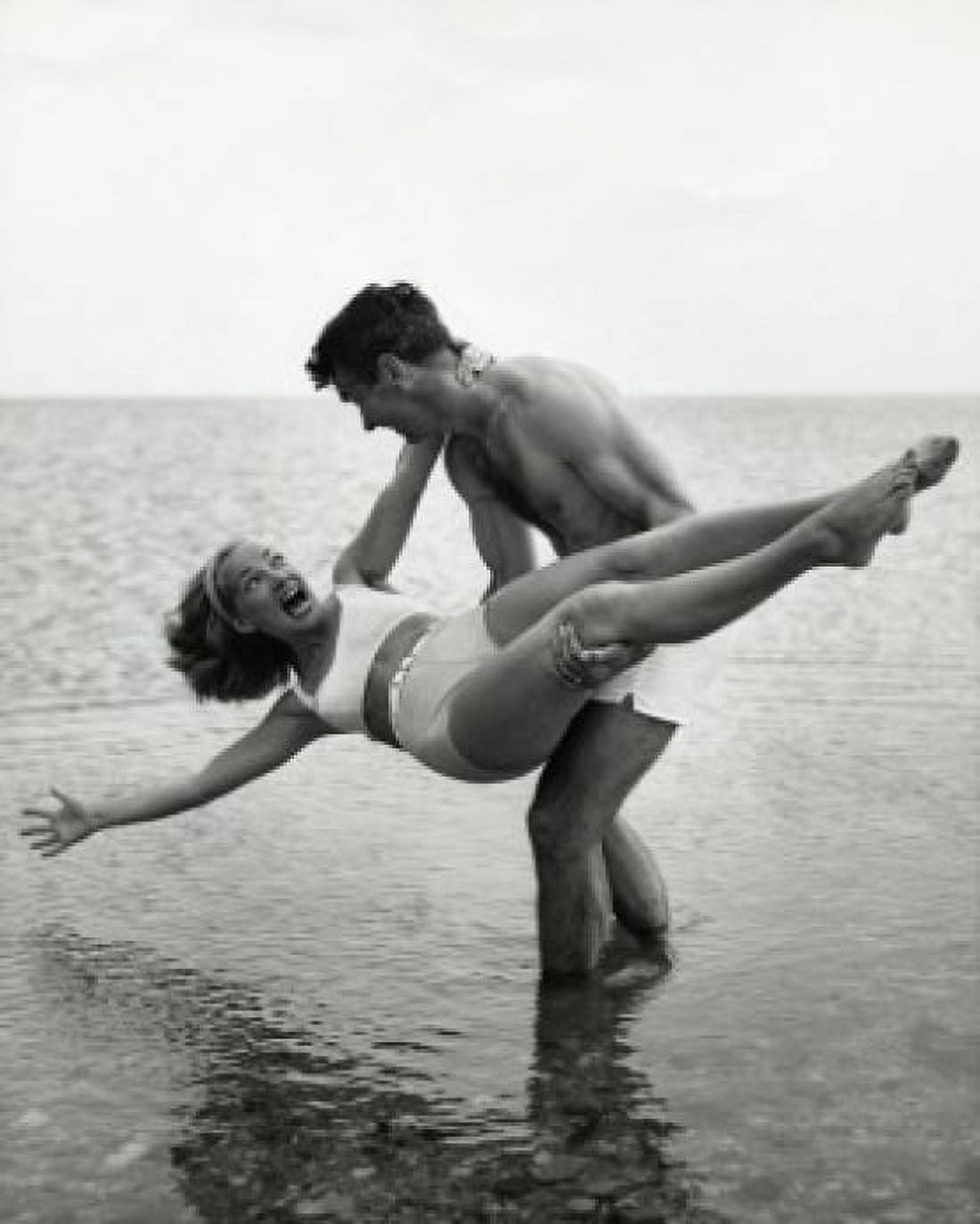 Young man carrying young woman on beach Canvas Art - (18 x 24)