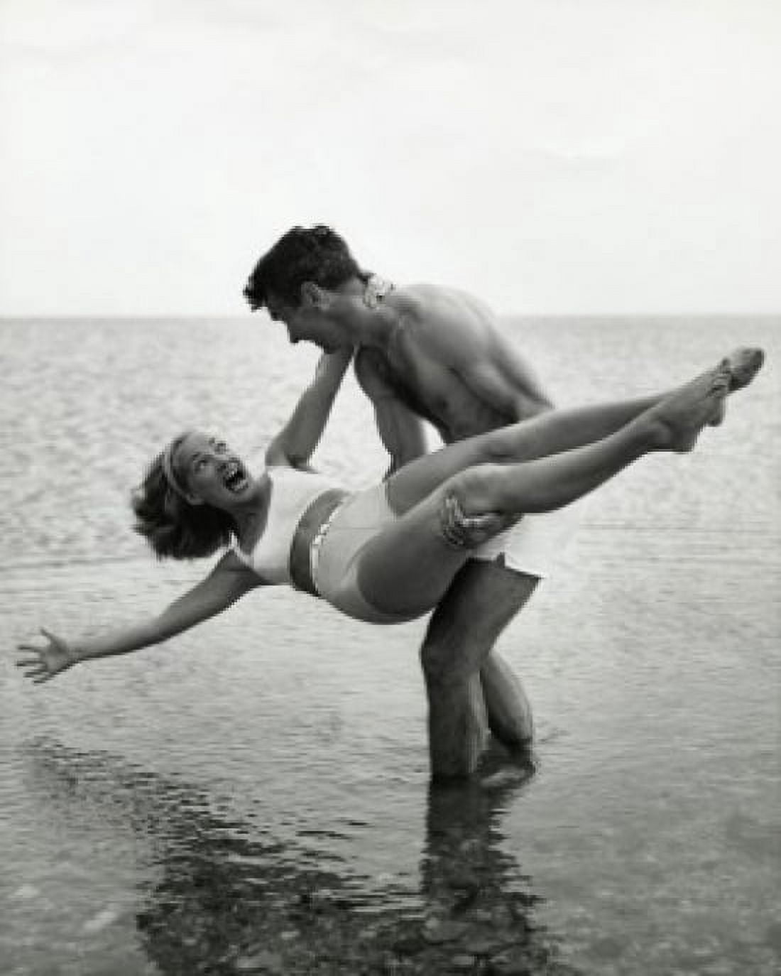Young man carrying young woman on beach Canvas Art - (24 x 36)