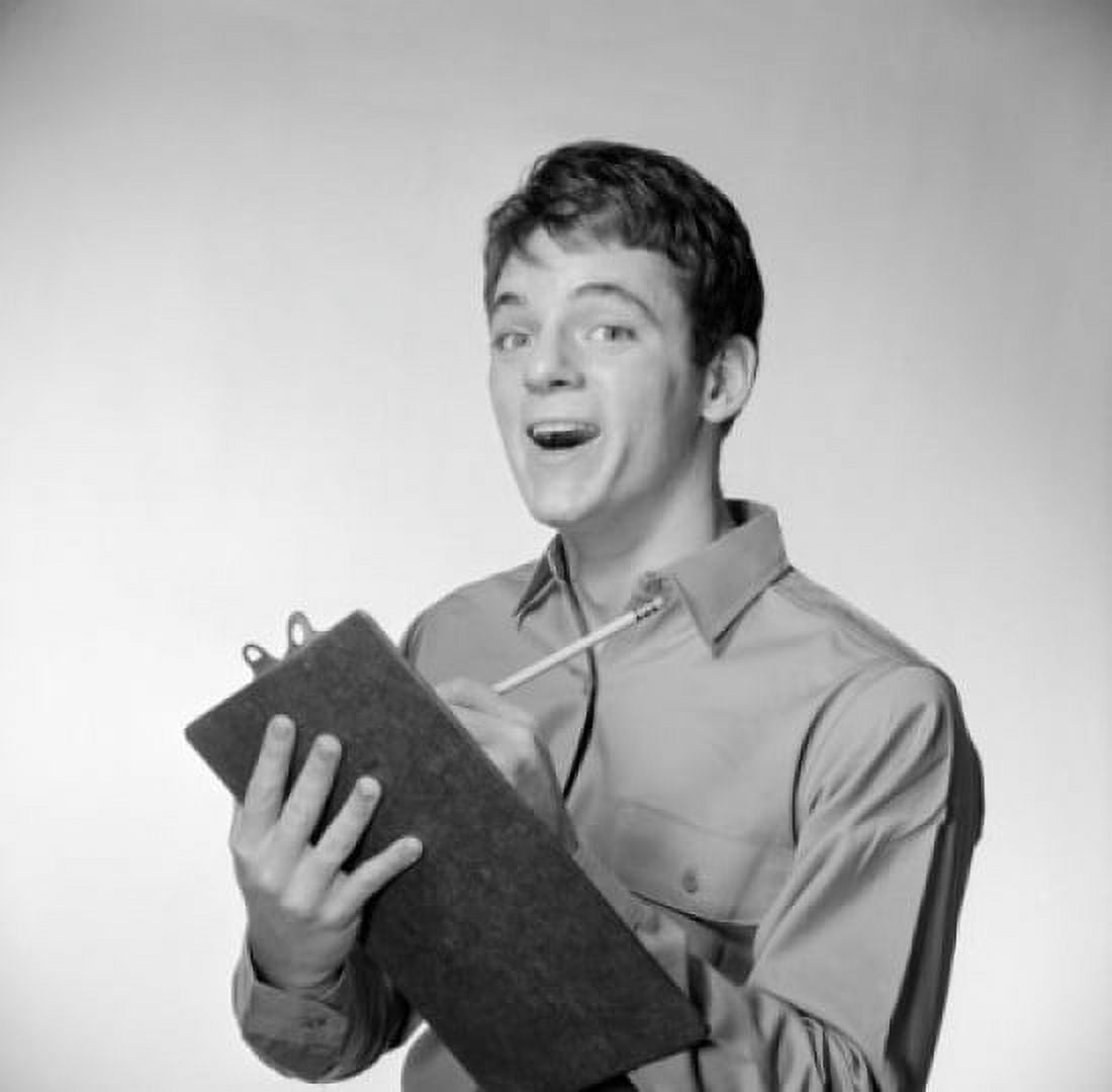 Young man holding writing pad making a face Canvas Art - (24 x 36)