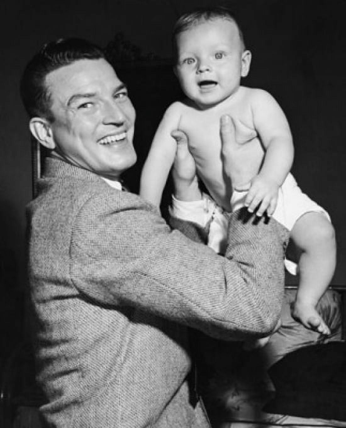 Young man picking up his baby and smiling Canvas Art - (24 x 36)