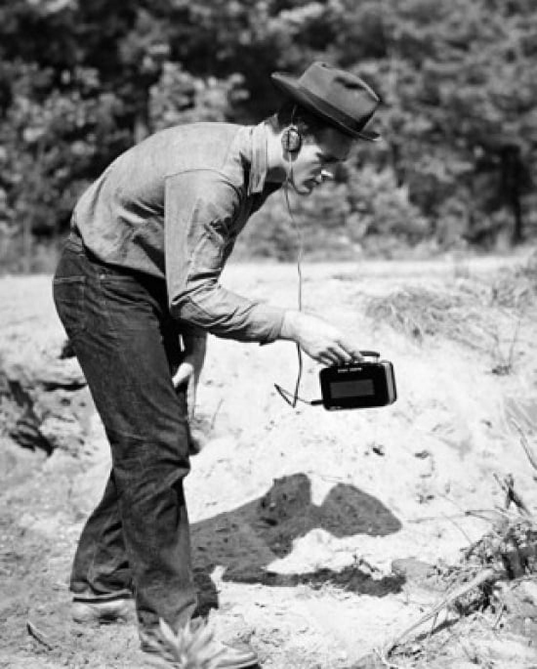 Young man searching for uranium in a rock with a geiger counter Canvas Art - (18 x 24)