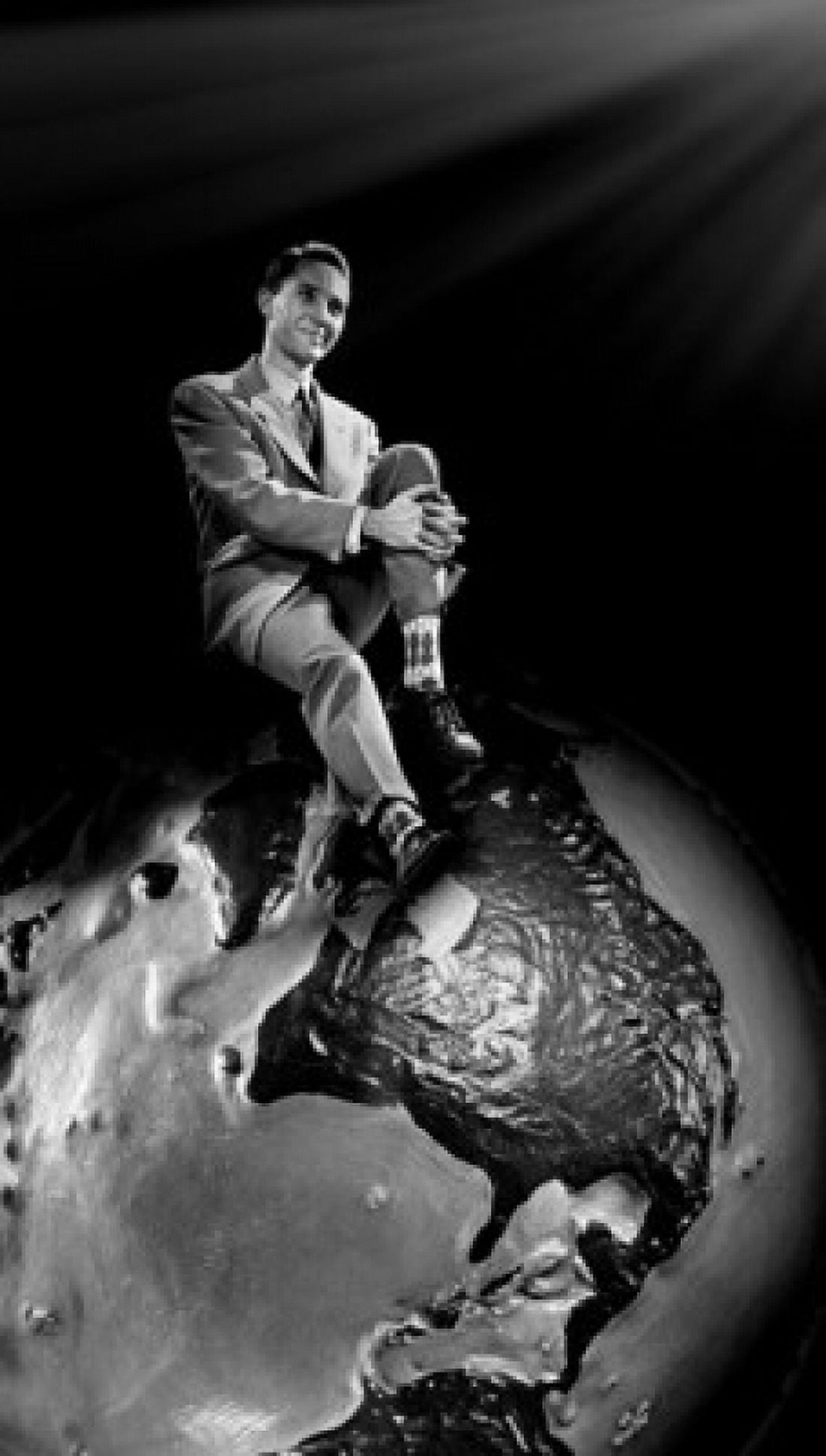 Young man sitting on top of globe Canvas Art - (24 x 36)