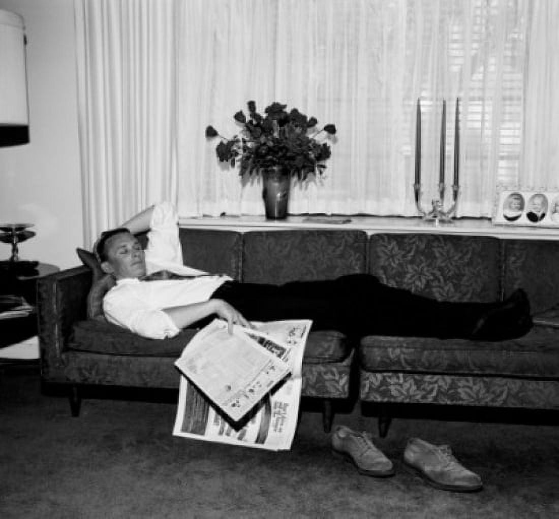 Young man sleeping on sofa in living room Canvas Art - (24 x 36)