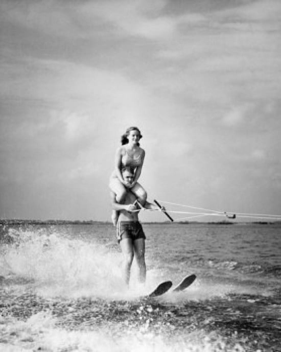 Young man waterskiing in sea with young woman sitting on his shoulders Canvas Art - (18 x 24)