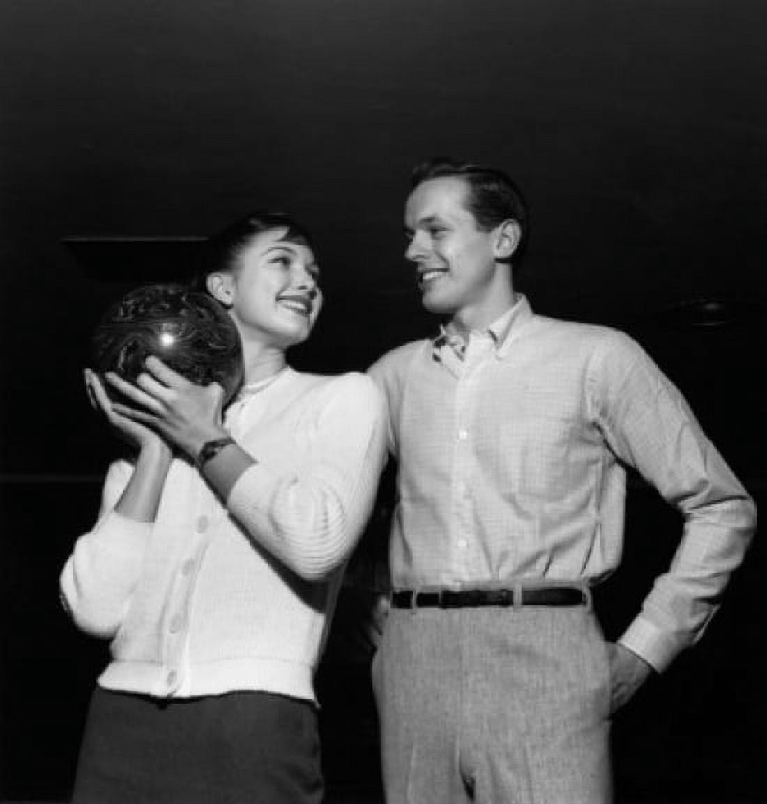 Young man with a young woman holding a bowling ball Canvas Art - (18 x 24)