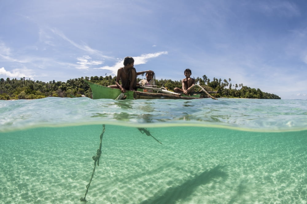 Young villagers fish off their outrigger near a remote island in Indonesia Canvas Art - Ethan DanielsStocktrek Images (17 x 12)