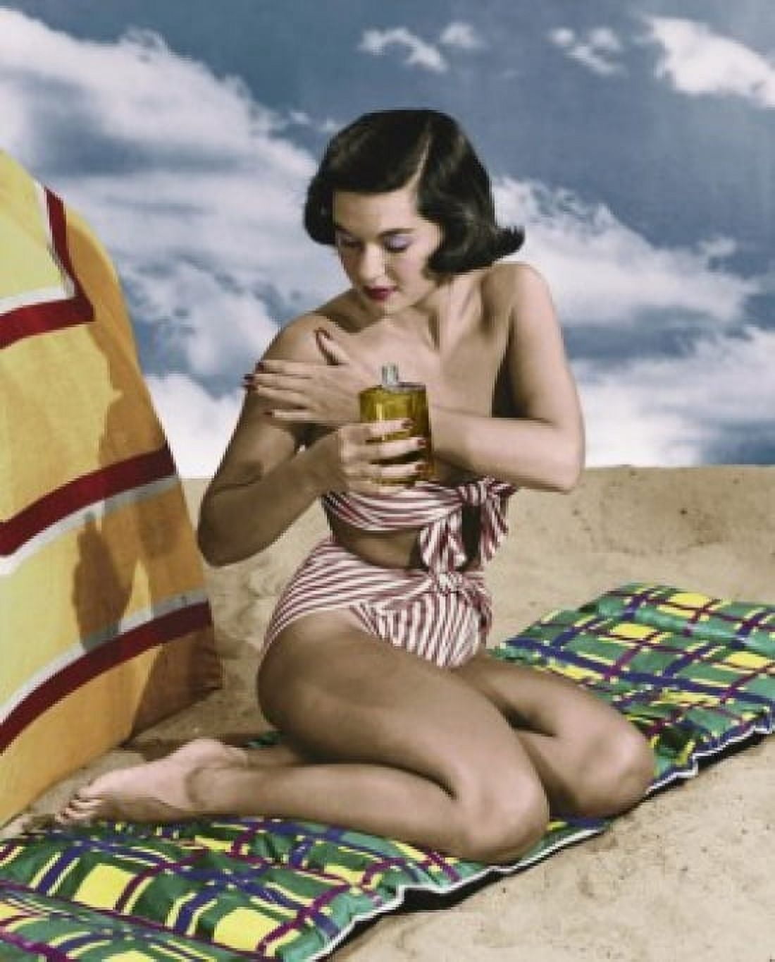Young woman applying suntan lotion on beach Canvas Art - (18 x 24)