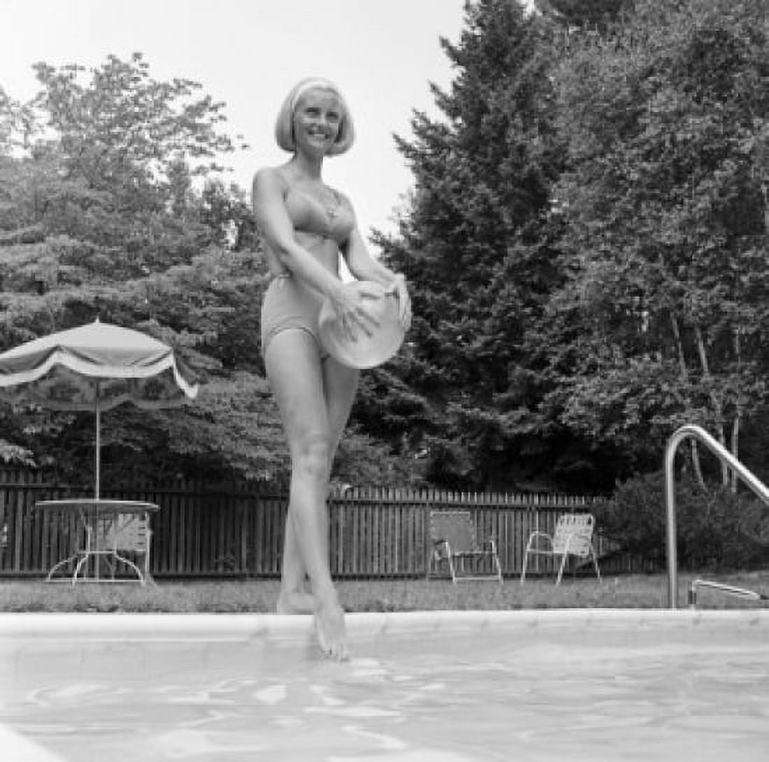 Young woman at edge of swimming pool holding rubber ball Canvas Art - (18 x 24)