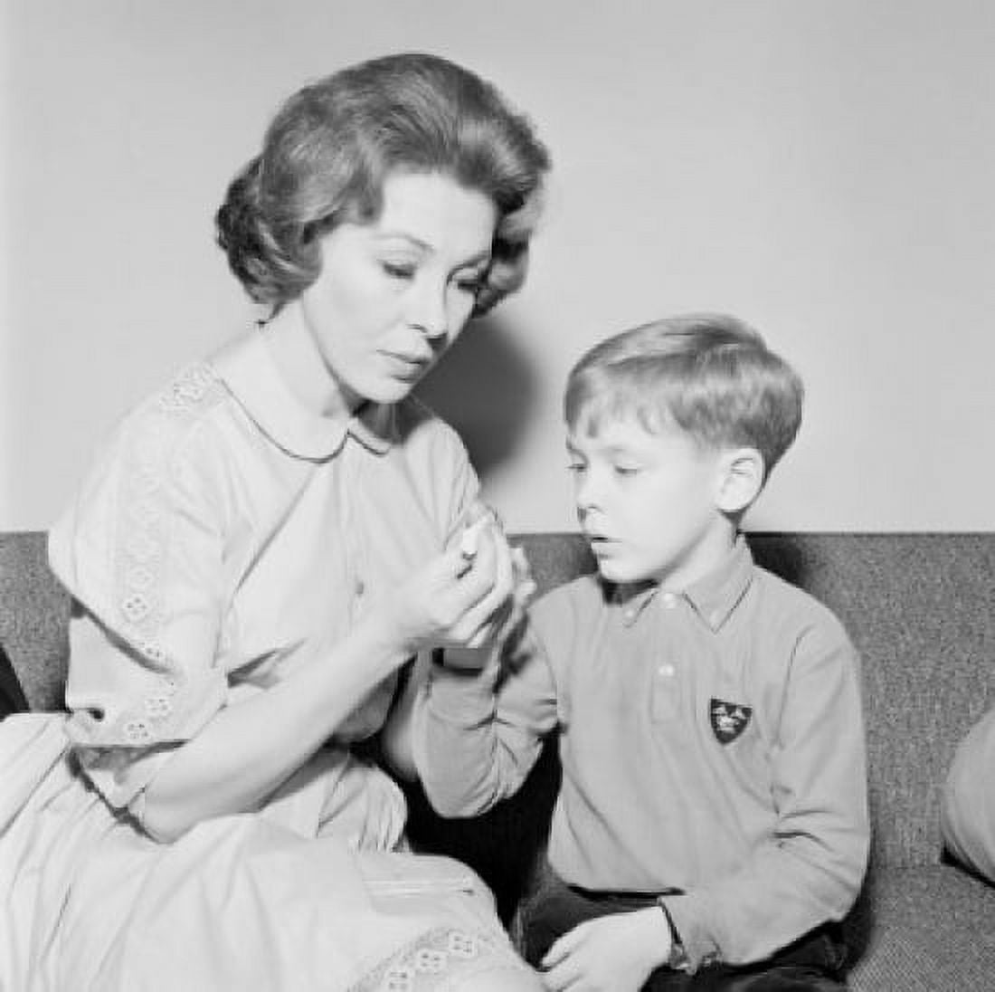 Young woman cutting boys nails Canvas Art - (24 x 36)