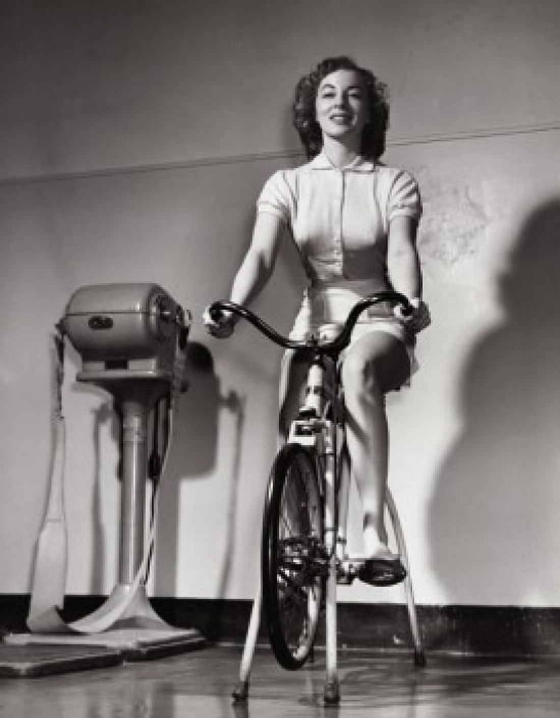 Young woman exercising on an exercise bike Canvas Art - (24 x 36)