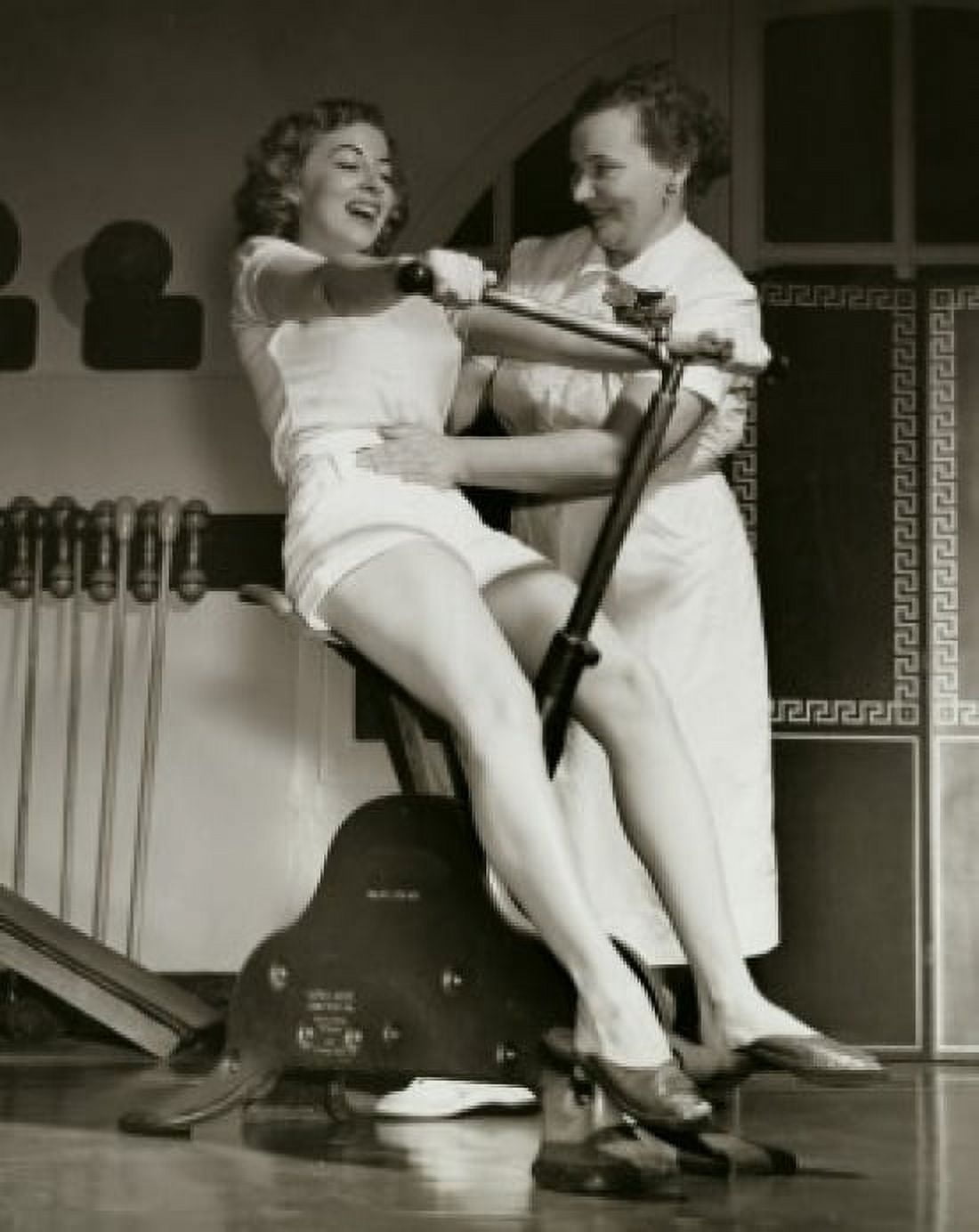 Young woman exercising on an exercise bike with her instructor touching her abdomen Canvas Art - (18 x 24)
