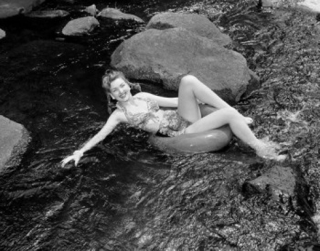 Young woman floating on water in inner tube Canvas Art - (24 x 36)