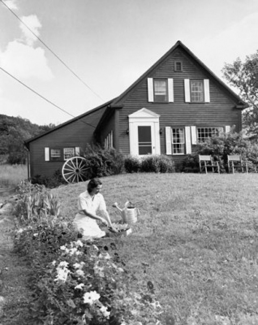 Young woman gardening in front of a house Canvas Art - (24 x 36)