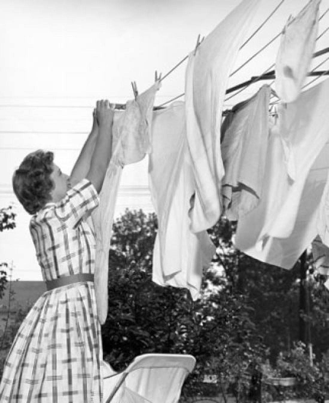 Young woman hanging clothes on a clothesline Canvas Art - (18 x 24)
