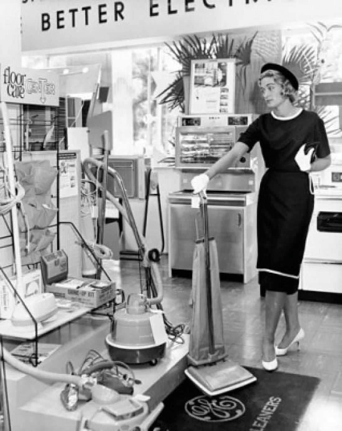 Young woman holding a vacuum cleaner in a store Canvas Art - (18 x 24)