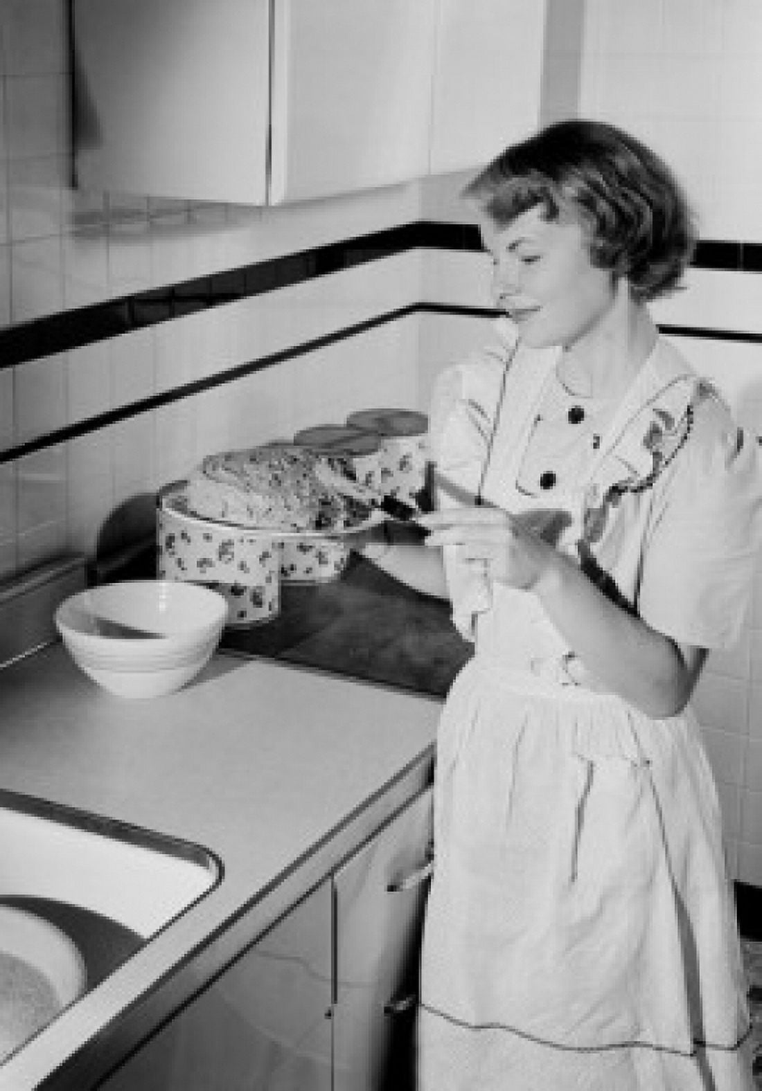 Young woman icing cake in kitchen Canvas Art - (24 x 36)
