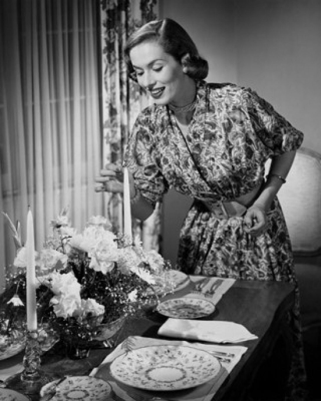 Young woman lighting a candle at a dining table Canvas Art - (18 x 24)