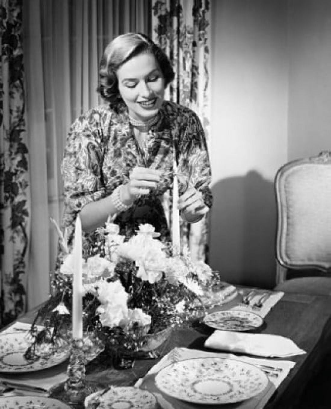 Young woman lighting a candle at a dining table Canvas Art - (18 x 24)