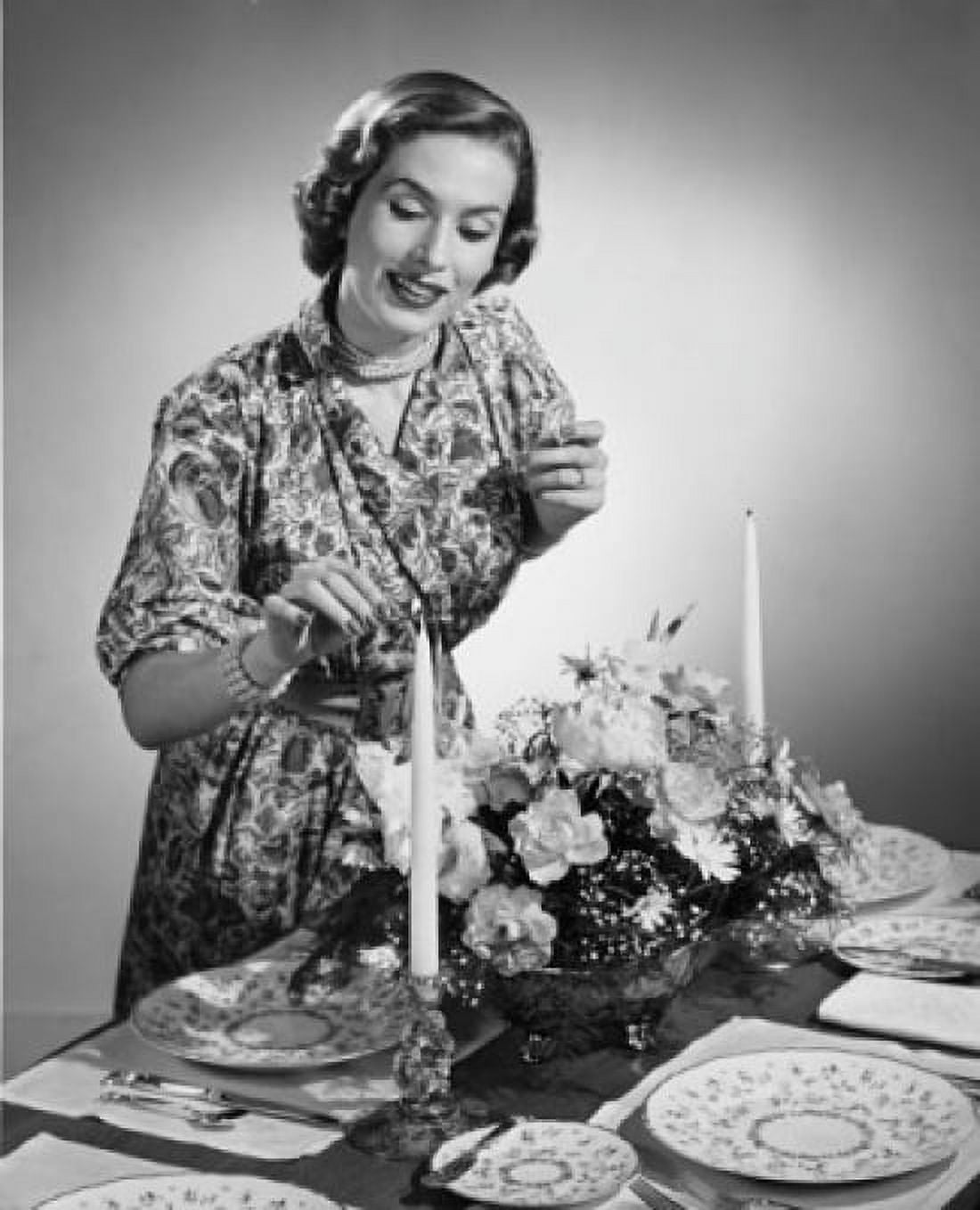 Young woman lighting a candle at a dining table Canvas Art - (24 x 36)
