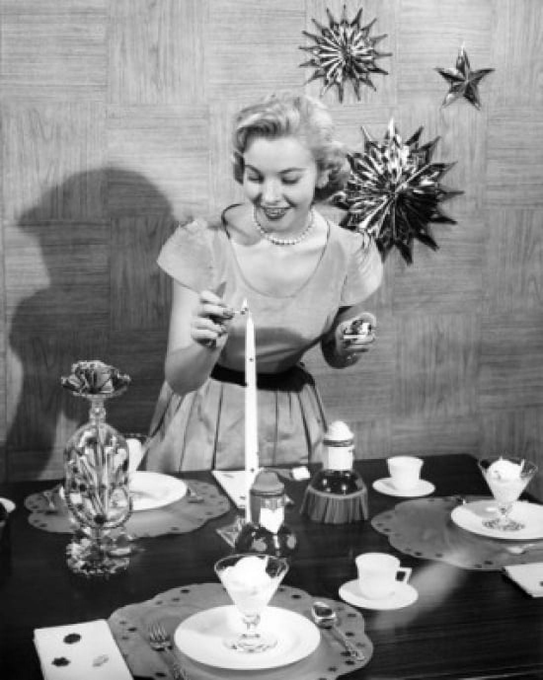 Young woman lighting a candle on a dining table Canvas Art - (18 x 24)