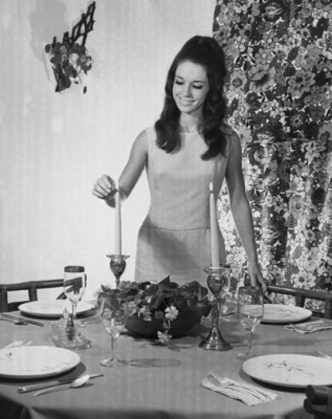 Young woman lighting a candle on a dining table Canvas Art - (24 x 36)