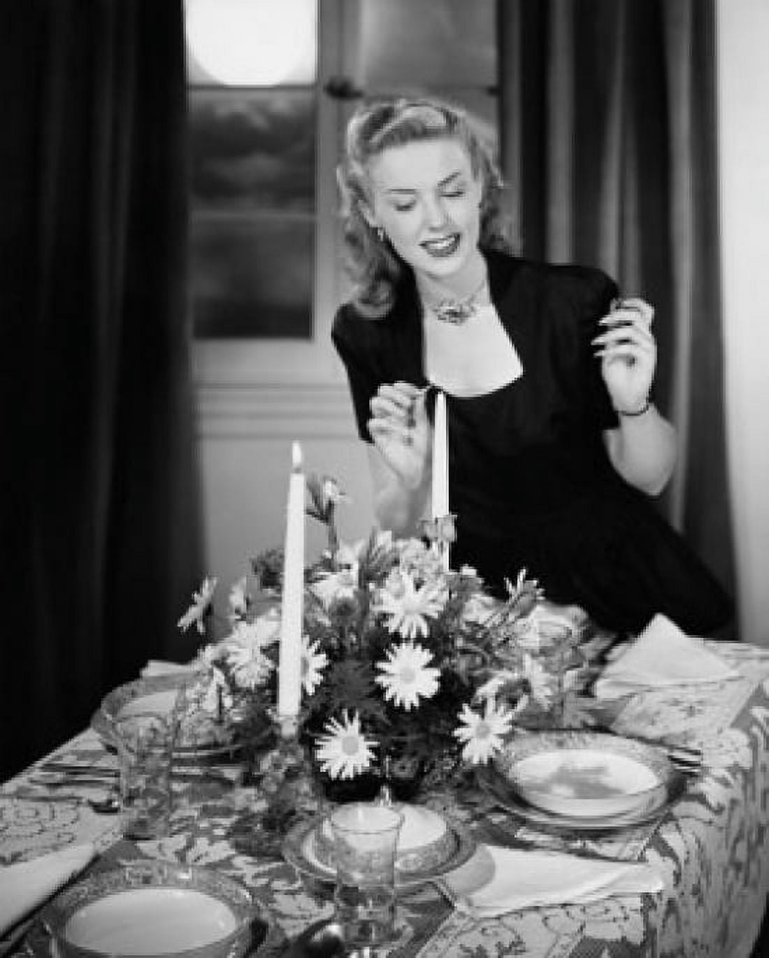 Young woman lighting candle at dining table Canvas Art - (24 x 36)
