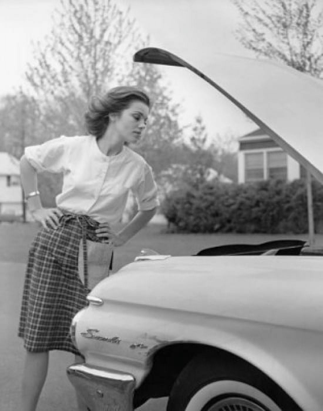 Young woman looking at a car engine Canvas Art - (24 x 36)