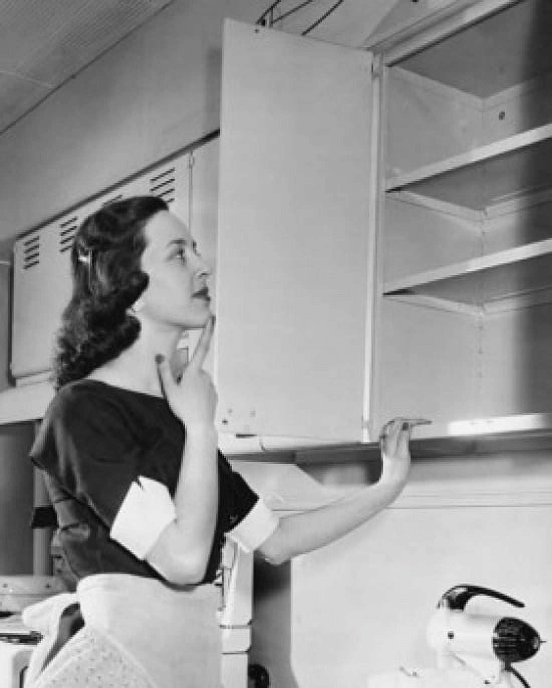 Young woman looking in an open cabinet Canvas Art - (18 x 24)
