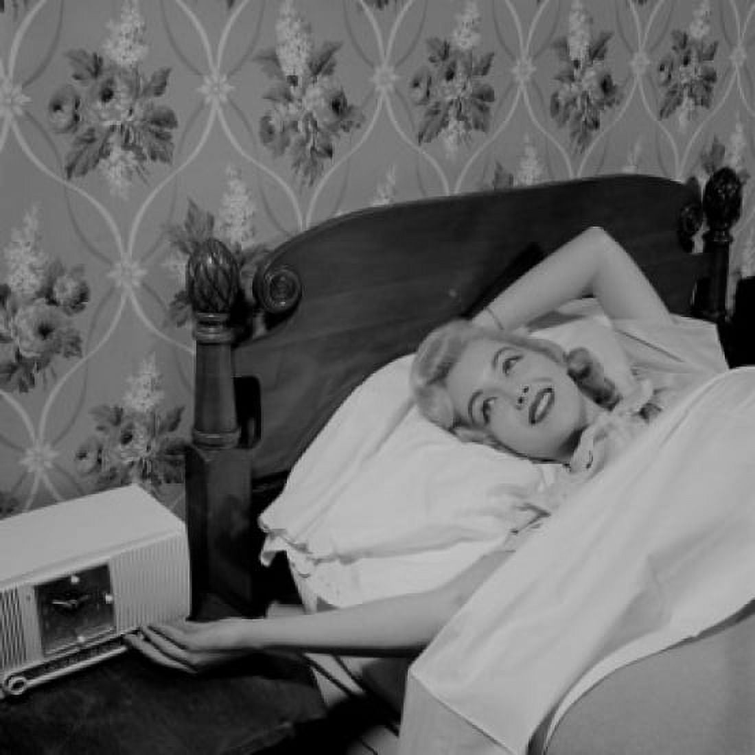 Young woman lying in bed listening to radio Canvas Art - (18 x 24)