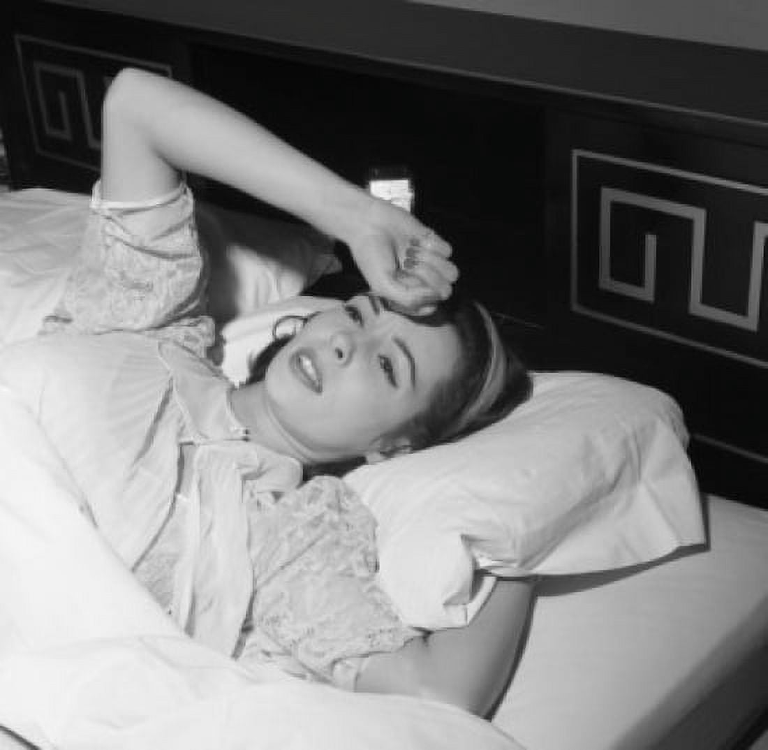 Young woman lying in bed with hand on forehead Canvas Art - (18 x 24)