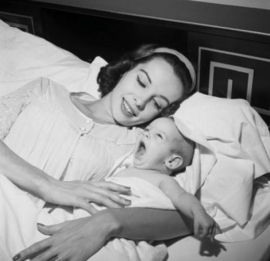 Young woman lying in bed with her baby Canvas Art - (18 x 24)