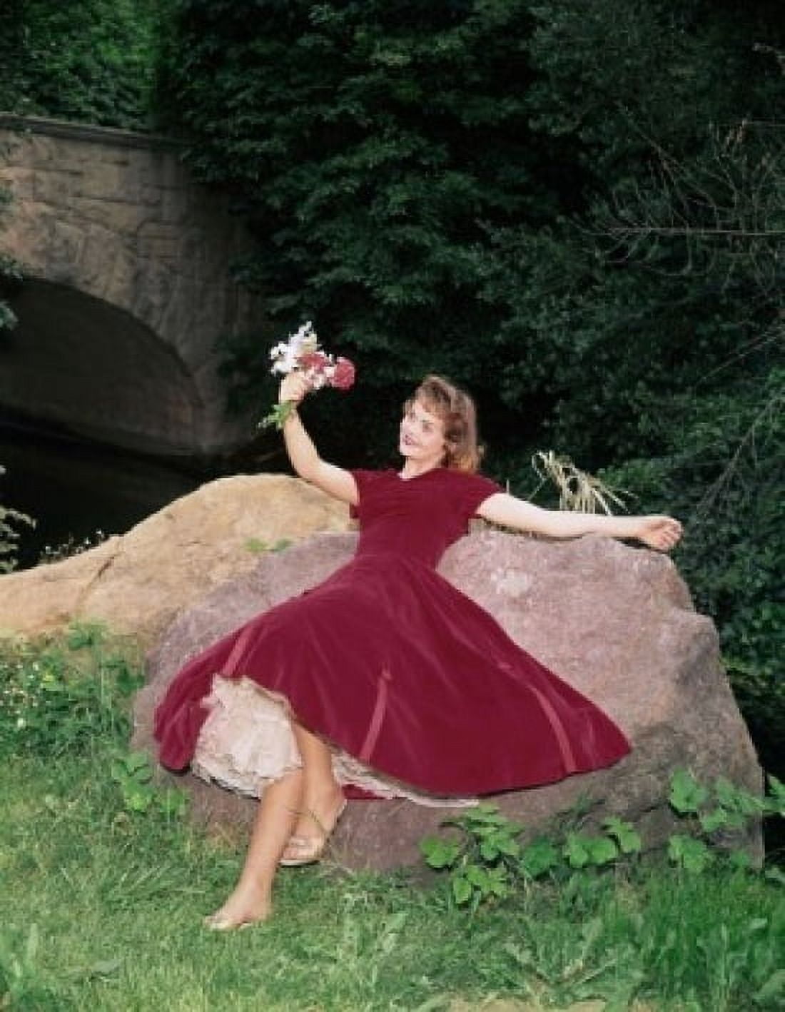 Young woman lying on a rock and holding a bunch of flowers Canvas Art - (24 x 36)
