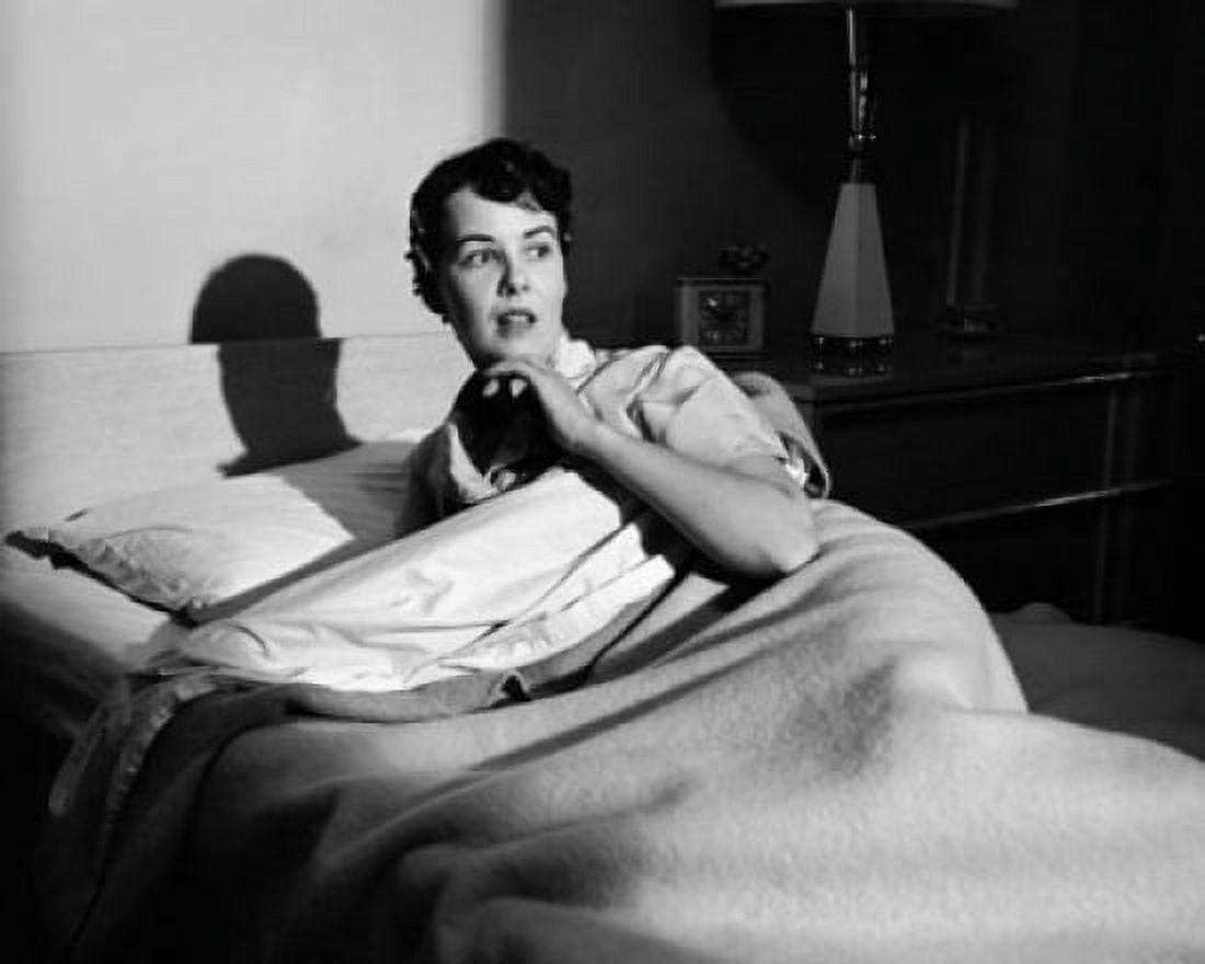Young woman lying on the bed and looking afraid Canvas Art - (24 x 36)